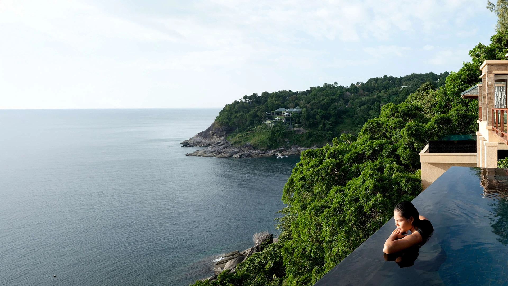 woman in pool overlooking ocean